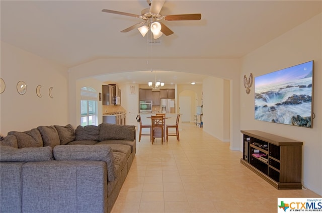 living room with ceiling fan with notable chandelier and light tile patterned floors