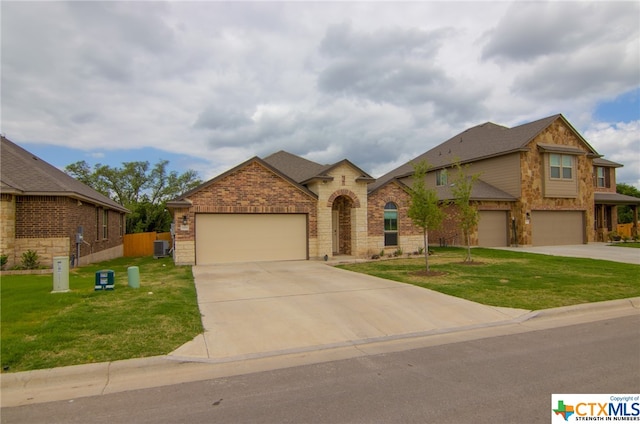 view of front of home with a garage, central AC, and a front yard