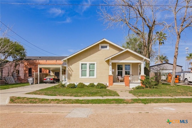 104 E Stayton Ave, Victoria, TX 77901 - bungalow with an attached carport, a porch, concrete driveway, and a front yard