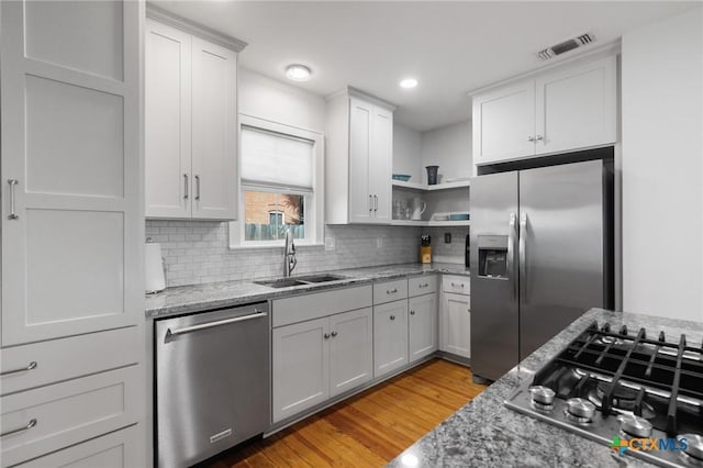 104 E Stayton Ave, Victoria, TX 77901 - kitchen with light stone countertops, visible vents, a sink, appliances with stainless steel finishes, and backsplash