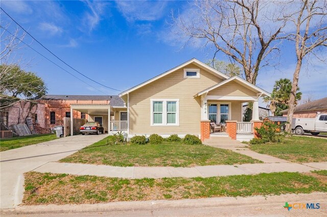 104 E Stayton Ave, Victoria, TX 77901 - bungalow featuring an attached carport, a porch, a front lawn, and driveway