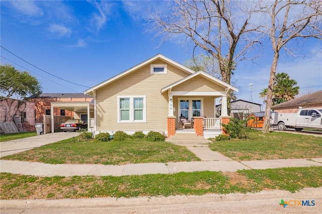 104 E Stayton Ave, Victoria, TX 77901 - bungalow featuring driveway, an attached carport, a porch, and a front yard