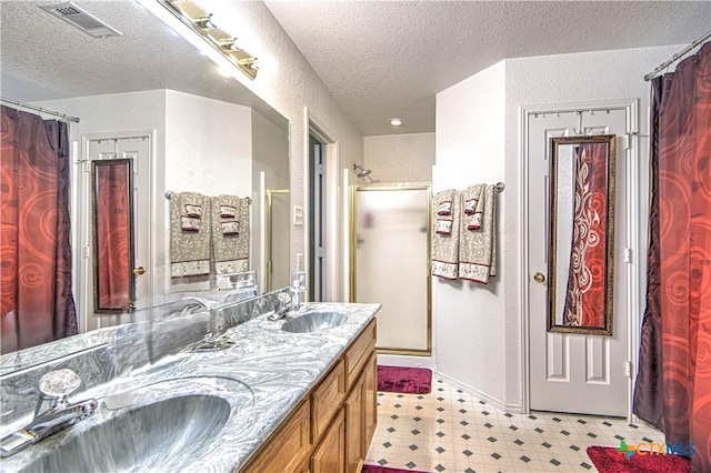 bathroom featuring vanity, a textured ceiling, and walk in shower