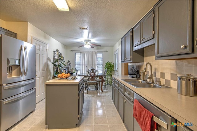 kitchen featuring sink, backsplash, a center island, wood counters, and stainless steel fridge with ice dispenser