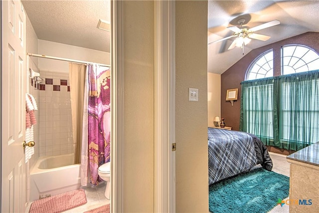 bedroom featuring connected bathroom, a textured ceiling, vaulted ceiling, and ceiling fan