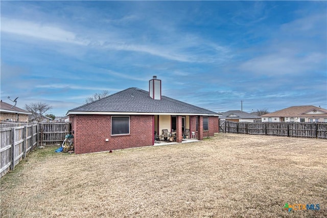 rear view of property featuring a lawn and a patio