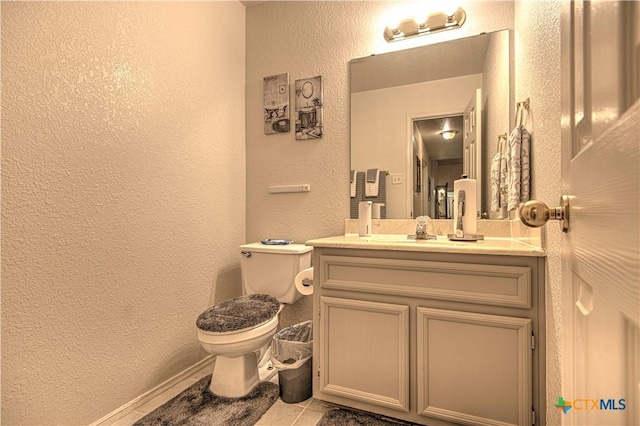 bathroom with tile patterned flooring, vanity, and toilet