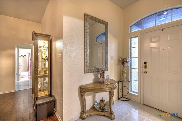 foyer entrance featuring light tile patterned flooring and a wealth of natural light