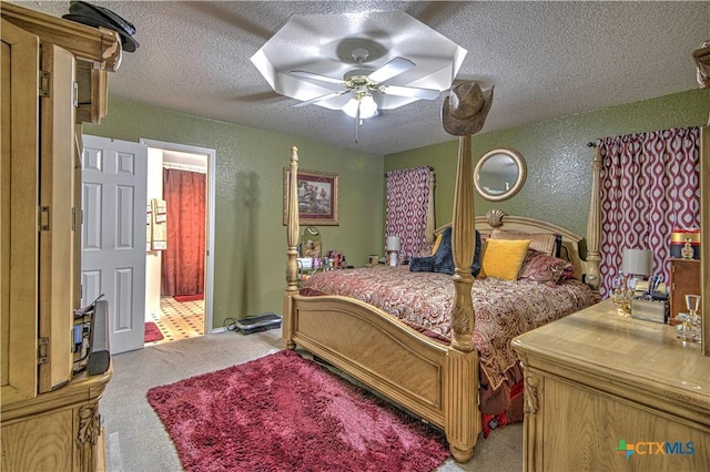 carpeted bedroom featuring ceiling fan and a textured ceiling