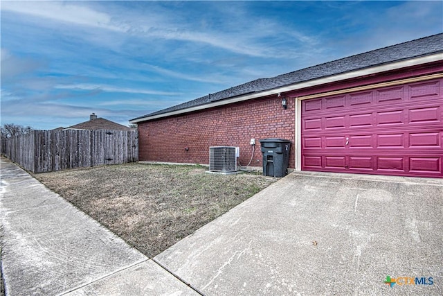 view of side of home featuring a garage and central air condition unit