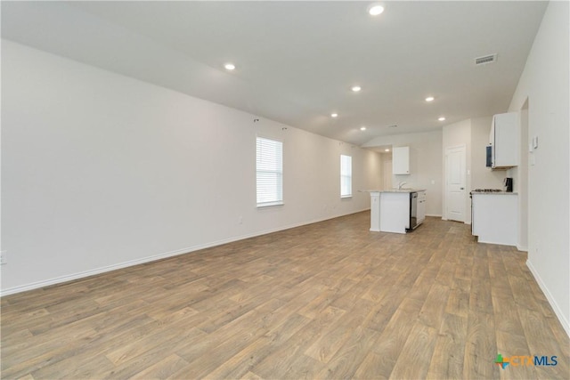 2969 Wolfcreek, New Braunfels, TX 78130 - unfurnished living room featuring light wood-style floors, recessed lighting, and baseboards