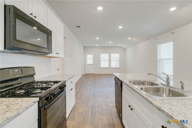 kitchen with a healthy amount of sunlight, hardwood / wood-style flooring, black appliances, and sink