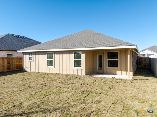 rear view of house with a yard and a patio