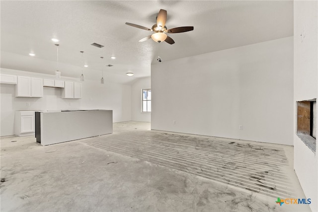 unfurnished living room featuring a textured ceiling and ceiling fan