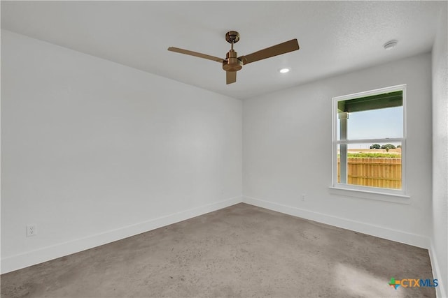 empty room featuring ceiling fan and concrete floors