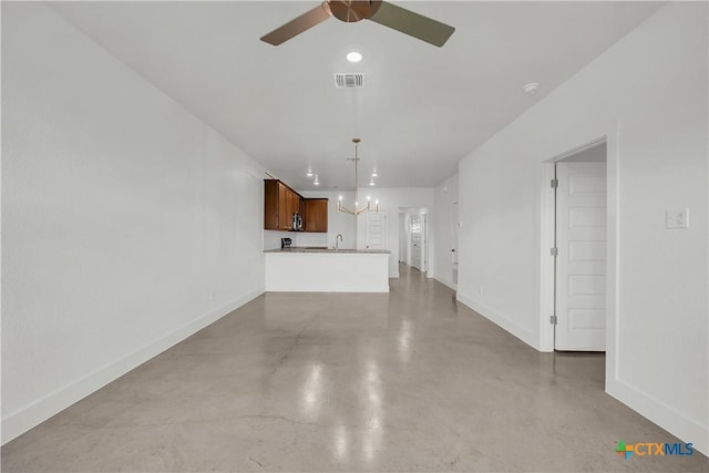 unfurnished living room with concrete flooring, sink, and ceiling fan with notable chandelier