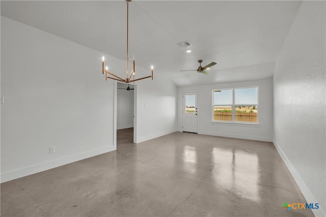 spare room featuring ceiling fan with notable chandelier, vaulted ceiling, and concrete floors