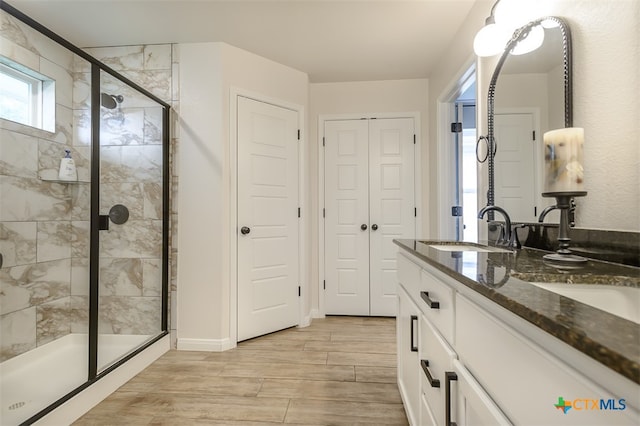 bathroom with walk in shower, vanity, and hardwood / wood-style flooring