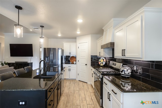 kitchen featuring pendant lighting, stainless steel appliances, sink, and white cabinets