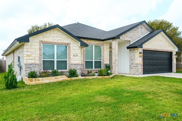 view of front of property featuring a garage and a front lawn