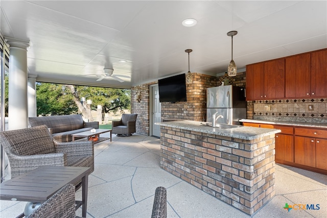 view of patio / terrace with outdoor lounge area, sink, and ceiling fan