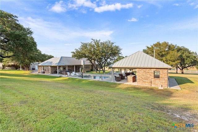 exterior space with a swimming pool, a patio area, a lawn, and a gazebo