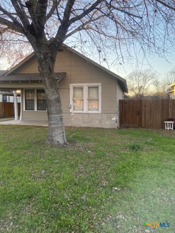 property exterior at dusk with a lawn