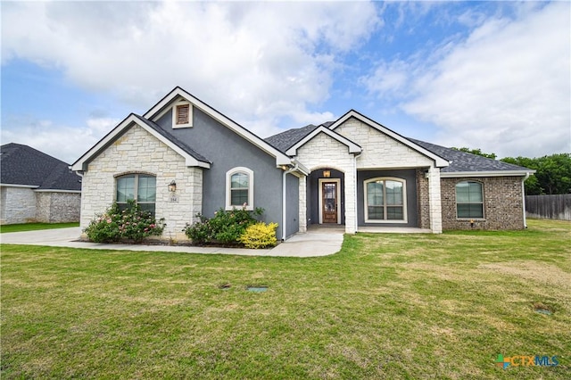 view of front of home featuring fence, a front yard, and stone siding
