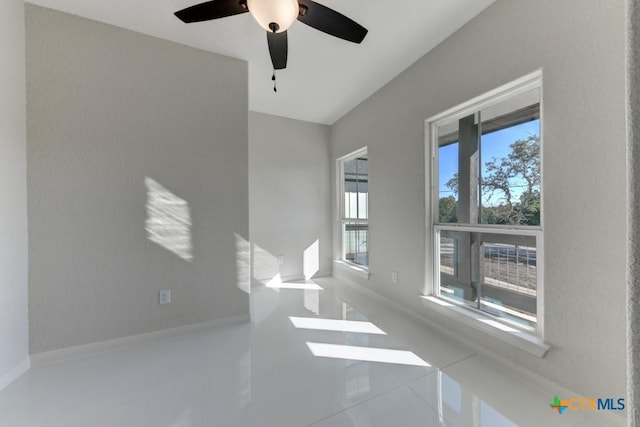 tiled empty room featuring ceiling fan