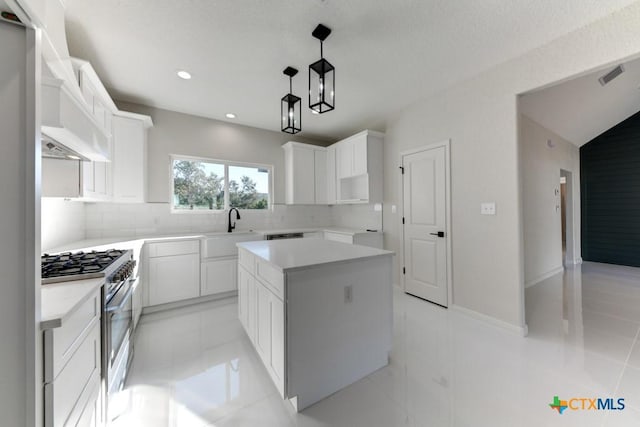 kitchen with gas range, a center island, and white cabinets