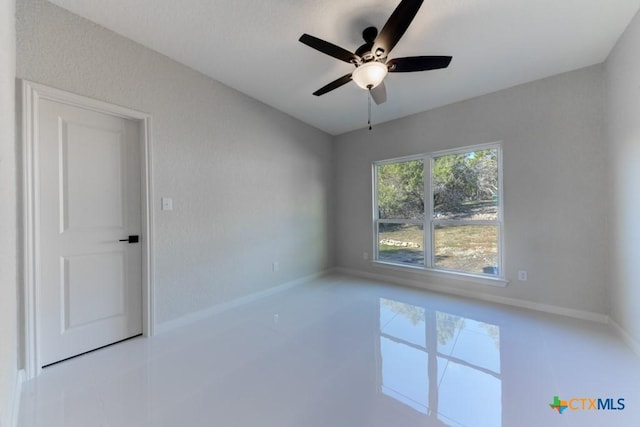 spare room featuring tile patterned flooring and ceiling fan