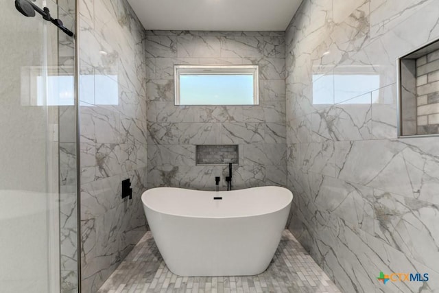 bathroom featuring a bathtub and tile walls