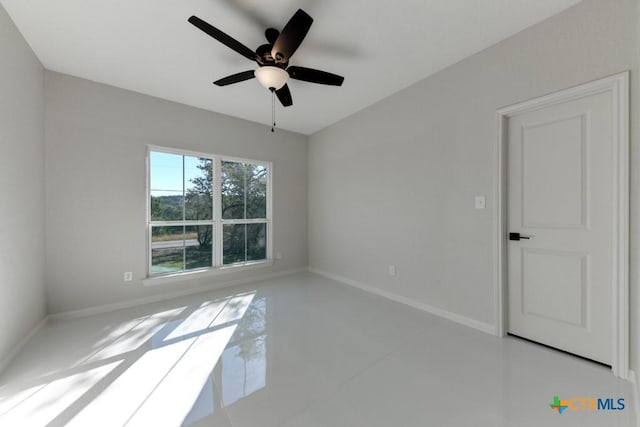 empty room featuring tile patterned flooring and ceiling fan