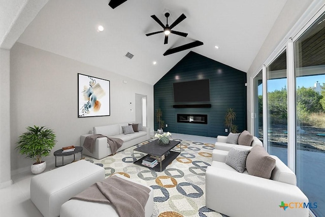 living room with ceiling fan, wood walls, a fireplace, and high vaulted ceiling