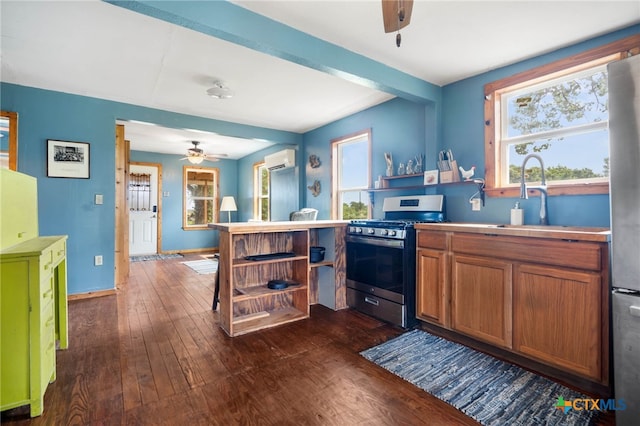 10843 US Highway 90, Harwood, TX 78632 - kitchen with appliances with stainless steel finishes, ceiling fan, a wall unit AC, dark wood-type flooring, and plenty of natural light