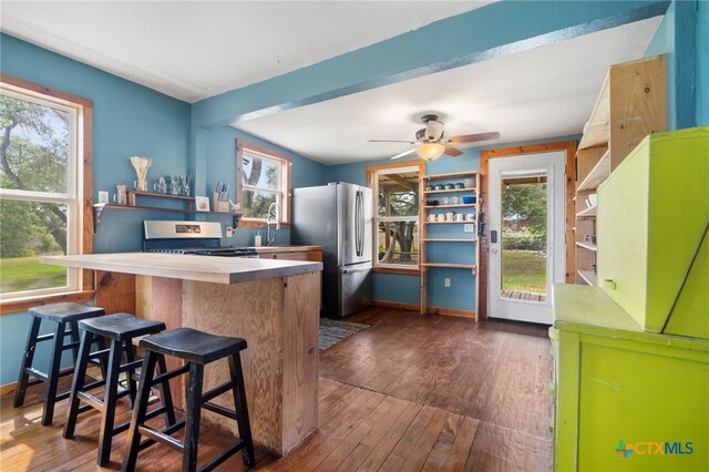 10843 US Highway 90, Harwood, TX 78632 - kitchen with range, freestanding refrigerator, dark wood finished floors, and ceiling fan