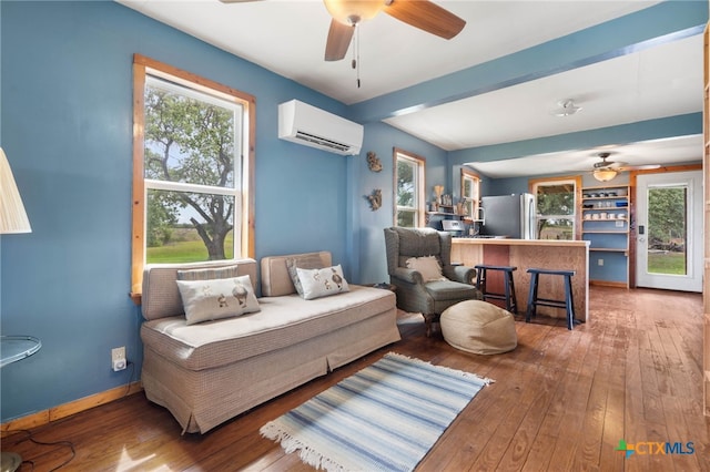 10843 US Highway 90, Harwood, TX 78632 - living room featuring a wall mounted air conditioner, a ceiling fan, hardwood / wood-style flooring, and plenty of natural light