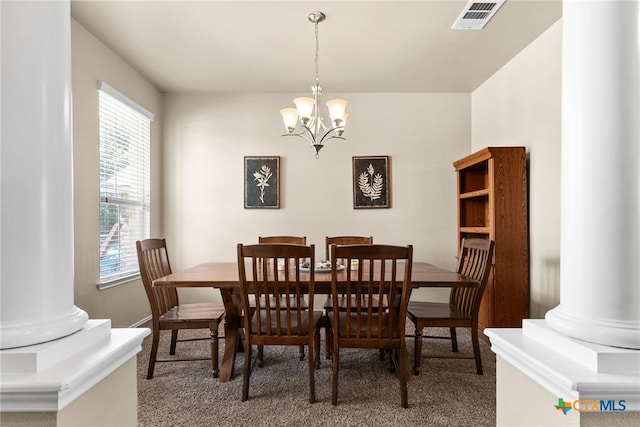 carpeted dining space with decorative columns and an inviting chandelier