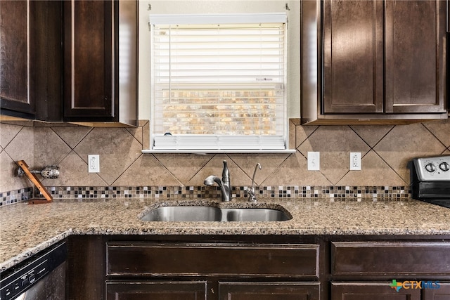 kitchen featuring stainless steel dishwasher, light stone counters, sink, and tasteful backsplash