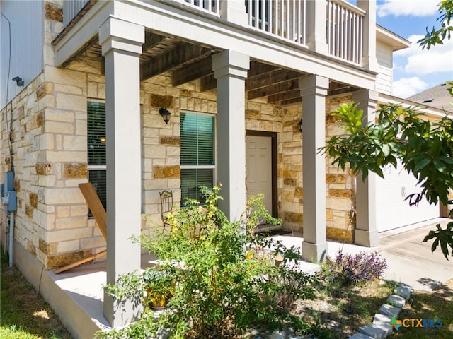 doorway to property with a garage and a balcony