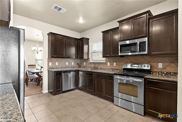 kitchen featuring light tile patterned floors, pendant lighting, appliances with stainless steel finishes, and tasteful backsplash