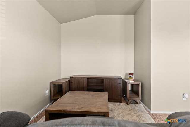 office with vaulted ceiling and light colored carpet