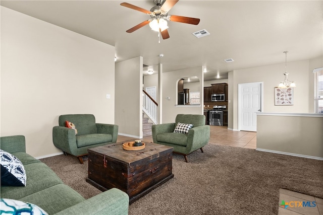 living room featuring light colored carpet and ceiling fan with notable chandelier