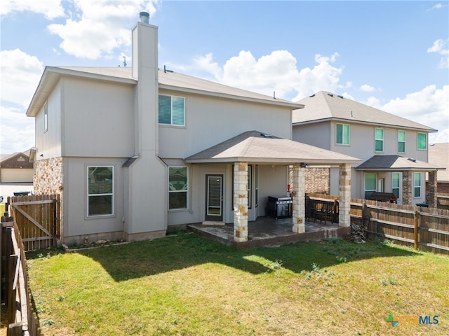 back of property with a patio and a yard