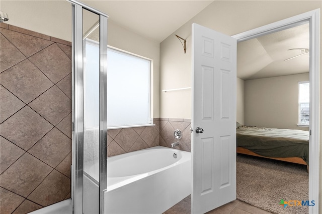 bathroom featuring independent shower and bath, lofted ceiling, and tile patterned floors