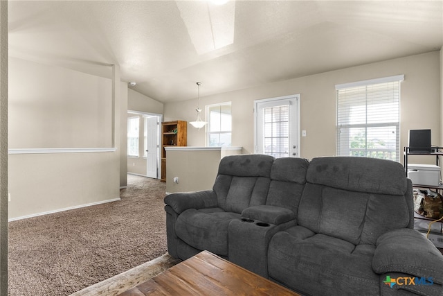 carpeted living room with lofted ceiling with skylight and a healthy amount of sunlight