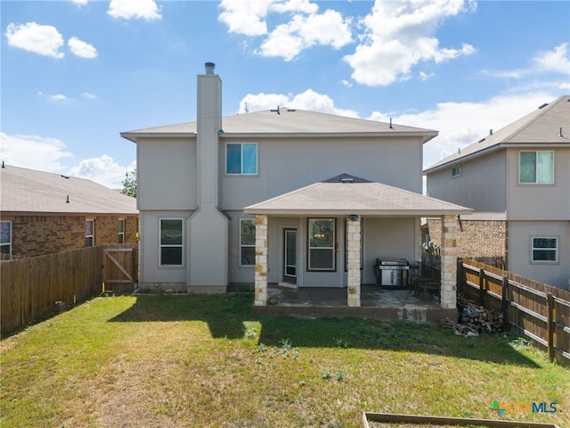 rear view of property with a lawn and a patio area