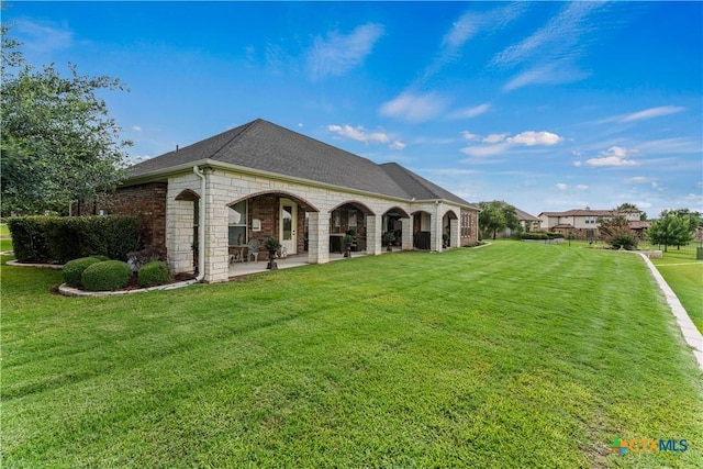 2747 Hester Way, Salado, TX 76571 - rear view of property featuring a yard, stone siding, roof with shingles, and a patio area