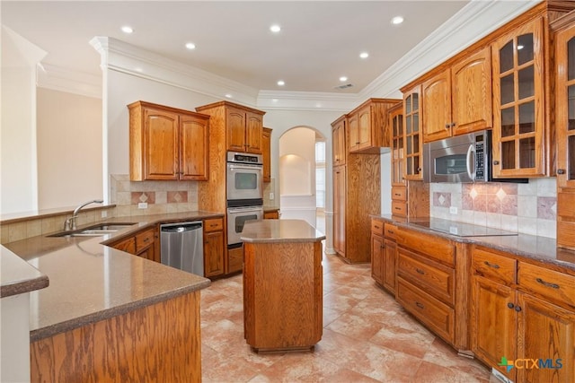 2747 Hester Way, Salado, TX 76571 - kitchen with stainless steel appliances, ornamental molding, arched walkways, a sink, and brown cabinetry