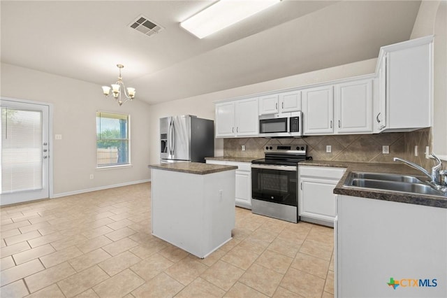 711 Leo Ln, Killeen, TX 76542 - kitchen featuring appliances with stainless steel finishes, backsplash, a chandelier, white cabinets, and vaulted ceiling